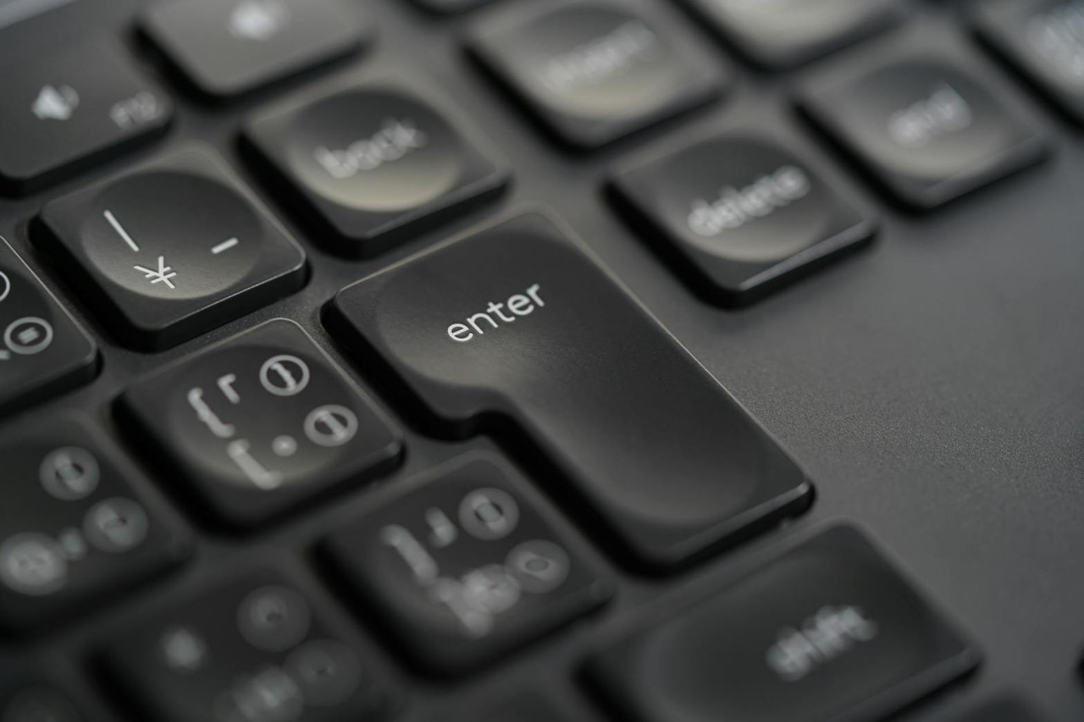 Silhuetten av en person står i mynningen till en vattenfylld gränd och blickar ut över en bukt och staden på andra sidan.